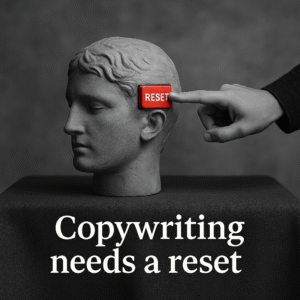 Conceptual image showing copywriting reset metaphor — stone head with a red button, symbolic of rethinking persuasive writing.
